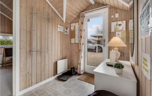 a home office with wooden walls and a door at Holiday Home Birkemose In Dnmk in Skovby