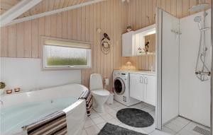 a bathroom with a tub and a toilet and a sink at Holiday Home Birkemose In Dnmk in Skovby