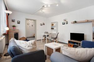 a living room with a couch and a tv at Wanderpfotens Ostsee Ferienhaus in Tribsees