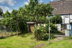 a house with a tree in the yard at Wanderpfotens Ostsee Ferienhaus in Tribsees