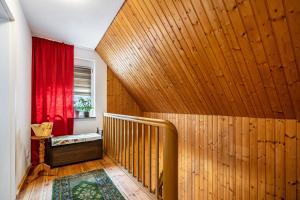 Una habitación con una escalera de madera con una cortina roja. en Ferienwohnung im Grünen, en Bad Muskau