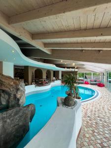 una piscina coperta in una casa con acqua blu di Hotel Post - OlangCard included a Valdaora
