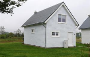 une maison blanche avec un toit gris sur une cour dans l'établissement Seeperle, à Olpenitz