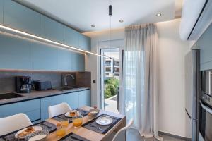 a blue kitchen with a table and chairs in a room at Santa Marina Luxury Apartments #1 with pool in Asgourou