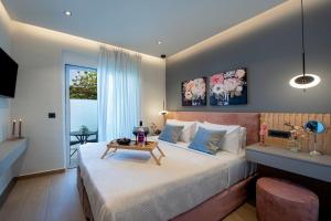 a bedroom with a large bed with a table on it at Santa Marina Luxury Apartments #1 with pool in Asgourou +14 photos