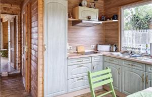 a kitchen with white cabinets and a green chair at Awesome Home In Burg Bei Magdeburg in Burg bei Magdeburg