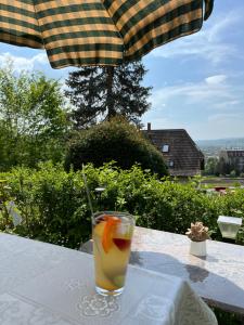 a drink sitting on a table under an umbrella at EMI2 Modern Apartment Free Parking Near Swiss Border in Waldshut-Tiengen