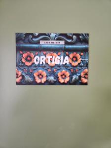 a sign on a wall with flowers on it at Lazy Olives in Tongeren
