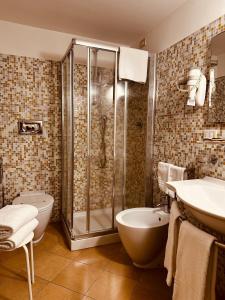 a bathroom with a shower and a sink and a toilet at Hotel Agathae in Catania