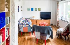 イースタッドにあるCozy Home In Ystad With Kitchenの椅子とテレビのあるリビングルーム
