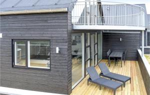 a house with a balcony with a table and two chairs at Three-Bedroom Holiday Home In Romo in Sønderby