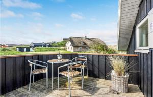 a patio with a table and chairs and a house at Holiday Home Krogen Ringkøbing in Søndervig