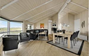 a living room with black furniture and a table at Holiday Home Krogen Ringkøbing in Søndervig