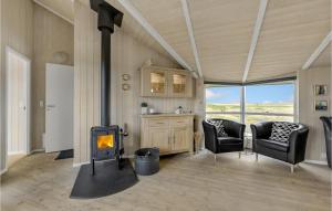 a living room with a stove and two chairs at Holiday Home Krogen Ringkøbing in Søndervig