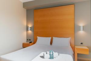 a bedroom with a white bed with a wooden headboard at B&B Hotel Pisa in Pisa