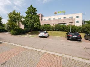 two cars parked in a parking lot in front of a hotel at B&B Hotel Faenza in Faenza