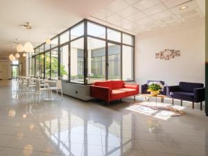 a lobby with a red couch and chairs at B&B Hotel Faenza in Faenza