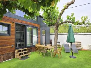 カネット・デ・マールにあるTiny House 1のテーブルと椅子と傘のあるパティオ