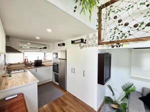 カネット・デ・マールにあるTiny House 1のキッチン(白いキャビネット、黒い冷蔵庫付)