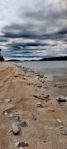 una spiaggia con rocce sulla sabbia e sull'acqua di Mobilna hiša Vitola a Drage