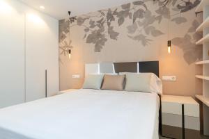 ein Schlafzimmer mit einem großen weißen Bett in einem Zimmer in der Unterkunft rentafive - Luxury - Reformado - 2 min Gran Playa in Santa Pola
