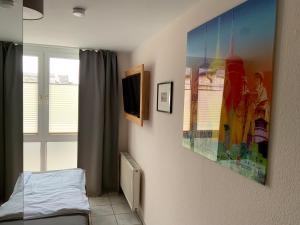 a room with a bed and a painting on the wall at Landgasthof zum Hasen in Meerbusch