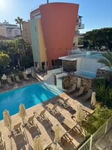 a swimming pool with chairs and a building at Antibes Port - Terrasse - Parking - Piscine in Antibes