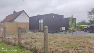 a black house with a car parked in front of it at Studio Smarty in Parigné-lʼÉvêque