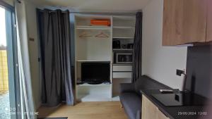a living room with a couch and a television at Studio Smarty in Parigné-lʼÉvêque