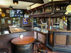 a bar with a wooden table and some bar stools at Landgasthof zum Hasen in Meerbusch