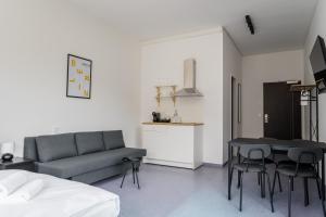 a living room with a couch and a table and chairs at Apartmenthaus Berlin Neukölln in Berlin
