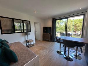 a living room with a couch and a table at Appartement neuf T2 avec jardin et terrasses in Arcachon