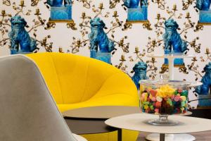 a table with a yellow chair and a bowl of candy at Hotel Haussmann Saint Augustin in Paris