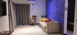 a living room with a couch and a brick wall at Complejo las Catalinas Dto 2 A in Puerto Madryn