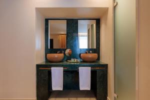 a bathroom with two sinks and a mirror at Asty Mykonos Hotel & Spa - World of One Hotel Group in Mikonos