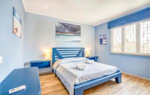 a blue bedroom with a bed and a window at 5 Bedroom Amazing Home In Torvaianica in Torvaianica