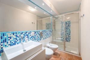 a bathroom with a sink and a toilet and a shower at Villa Perdalonga, Vista Mare Sea View Tuerredda in Teulada