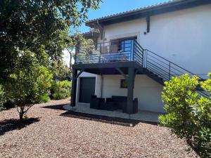a house with a staircase on the side of it at Appartement neuf T2 avec jardin et terrasses in Arcachon