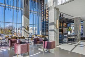 a lobby with tables and chairs and windows at Signia By Hilton Atlanta Georgia World Congress Center in Atlanta