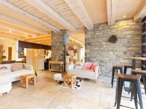 ein Wohnzimmer mit Sofas und einer Steinmauer in der Unterkunft Appartement central à Saint-Lary avec piscine, sauna et parking sécurisé - FR-1-296-398 in Saint-Lary-Soulan + 10 Fotos