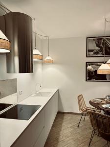 a white kitchen with a sink and a table at Villa Marina in Marina dʼAndora