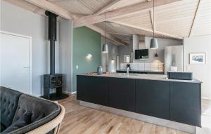 cocina con armarios negros y fogones en Holiday Home Aakirkeby With Fireplace 02, en Vester Sømarken