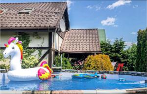 a pool with a unicorn float in front of a house at 4 Bedroom Cozy Home In Mscice in Mścice