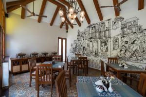 a restaurant with tables and chairs and a mural on the wall at Casa Albuquerque in Vagator