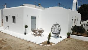 a white house with a table and chairs at Saint Barbara luxury home in Dhragoulás