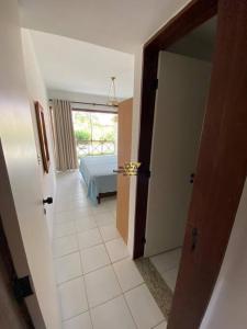 einen Flur mit einem Zimmer mit einem Bett und einer Tür in der Unterkunft Flat Monte Castelo, Gravatá in Bezerros