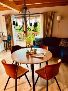 ein Wohnzimmer mit Tisch, Stühlen und Sofa in der Unterkunft Żuławska Osada in Trutnowy