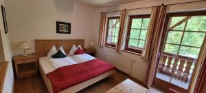 una camera da letto con un letto con una coperta rossa di Jagersimmerl a Grünau im Almtal