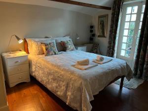 una camera da letto con un letto e un asciugamano sopra di Villa Portillon - charming fountain garden villa a Luchon