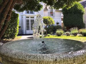 una fontana di fronte a una casa di Villa Portillon - charming fountain garden villa a Luchon Altre 15 foto